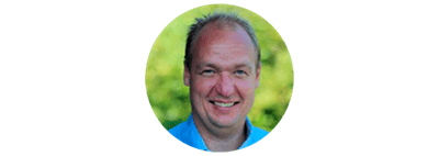 Smilende mand udendørs med grøn baggrund